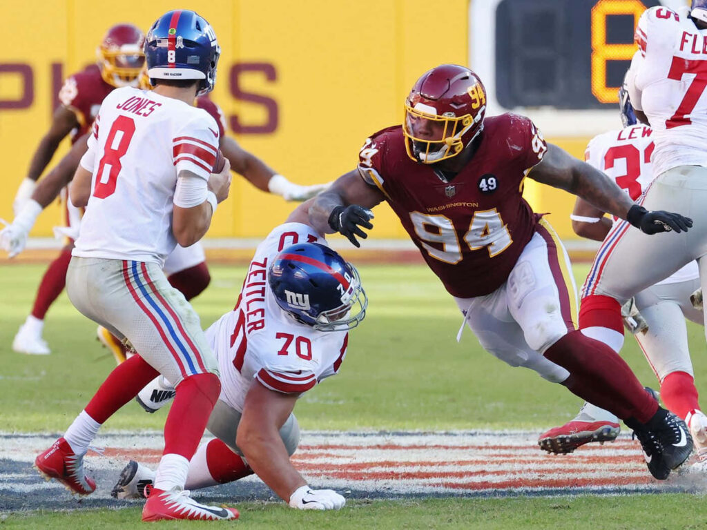 Daniel Jones New York Giants quarterback chased by Daron Payne Washington Commanders Kevin Zeitler blocks Wallpaper