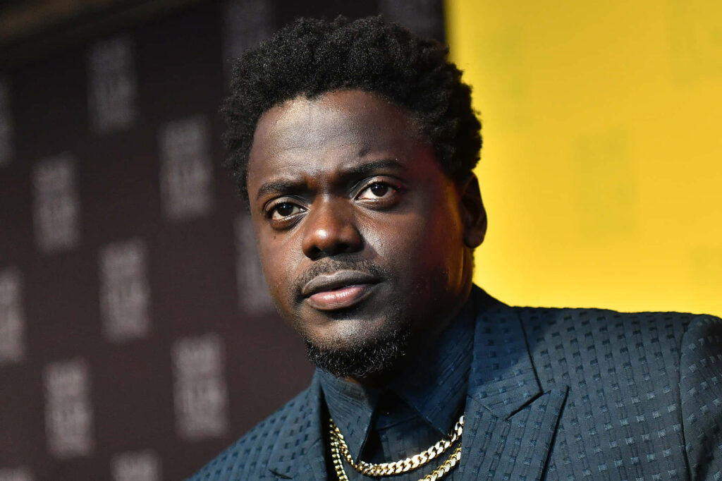 Daniel Kaluuya in patterned suit and gold necklaces vibrant black and yellow cinematic wallpaper background