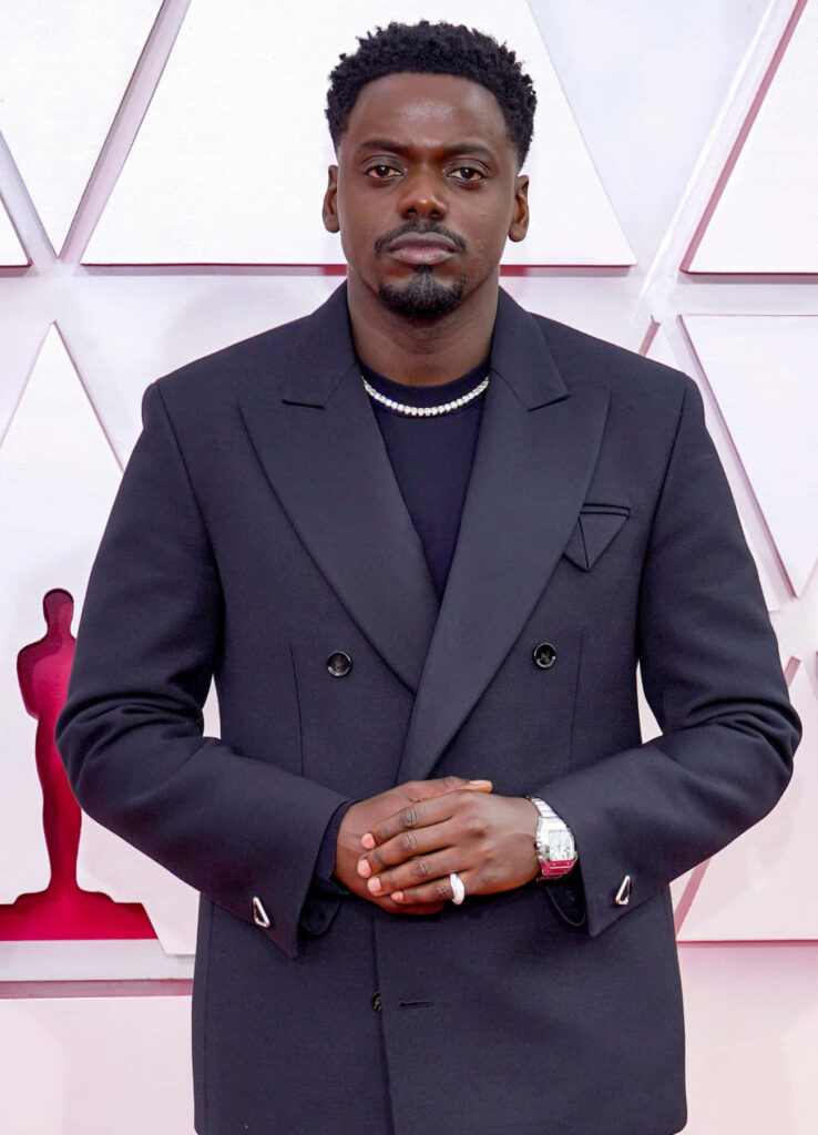 Daniel Kaluuya in sharp double-breasted black suit geometric light-toned background wallpaper