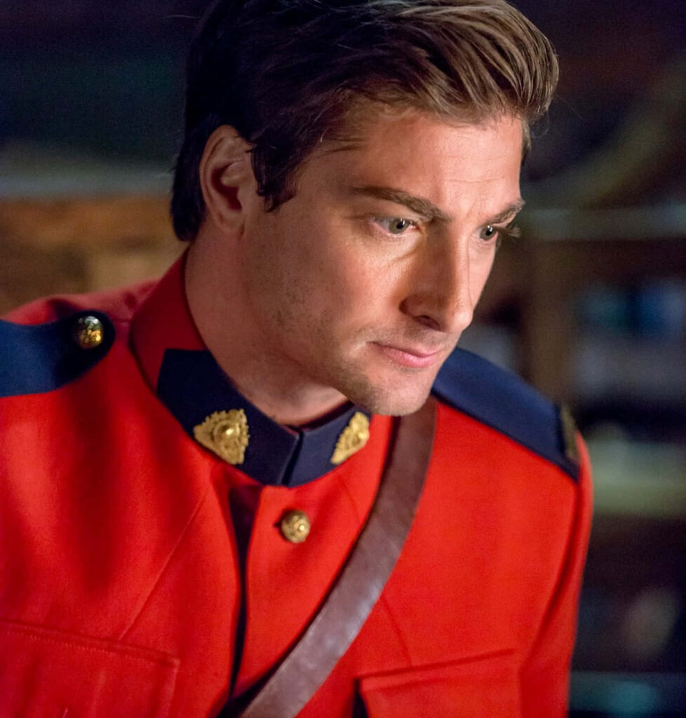 Daniel Lissing in classic red Mountie uniform with gold accents cinematic wallpaper background
