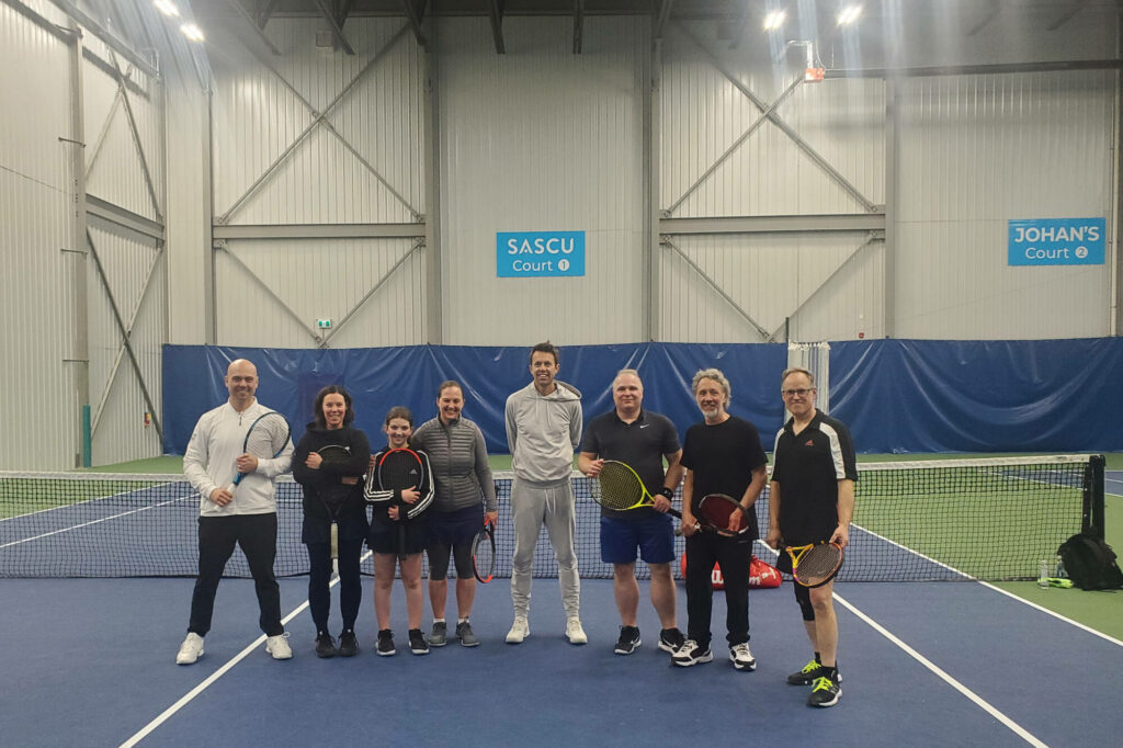 Daniel Nestor with fans and players smiling on indoor tennis court holding rackets in sportswear Wallpaper