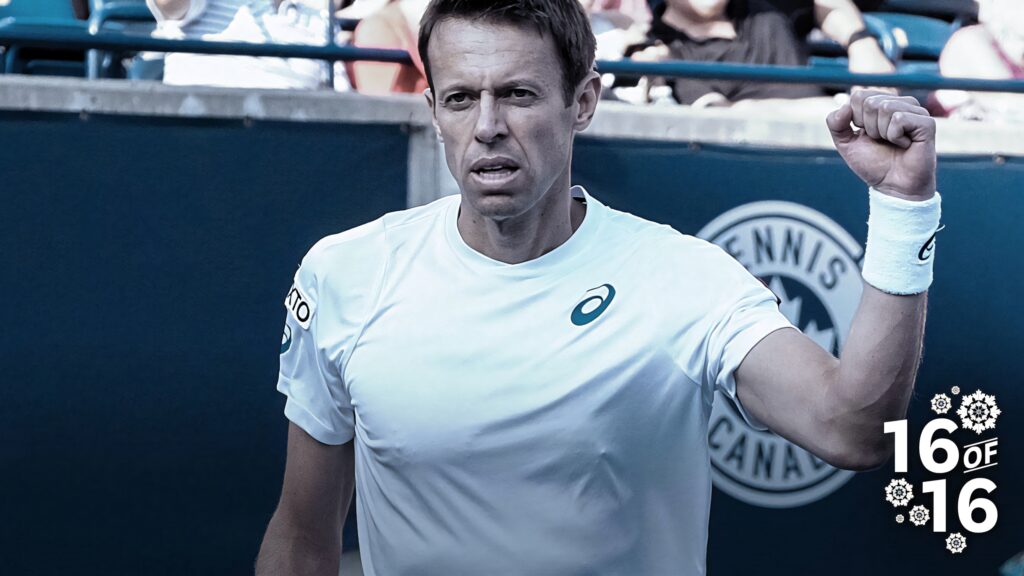 Daniel Nestor triumphant fist clenched celebrating victory on vivid tennis court wallpaper background