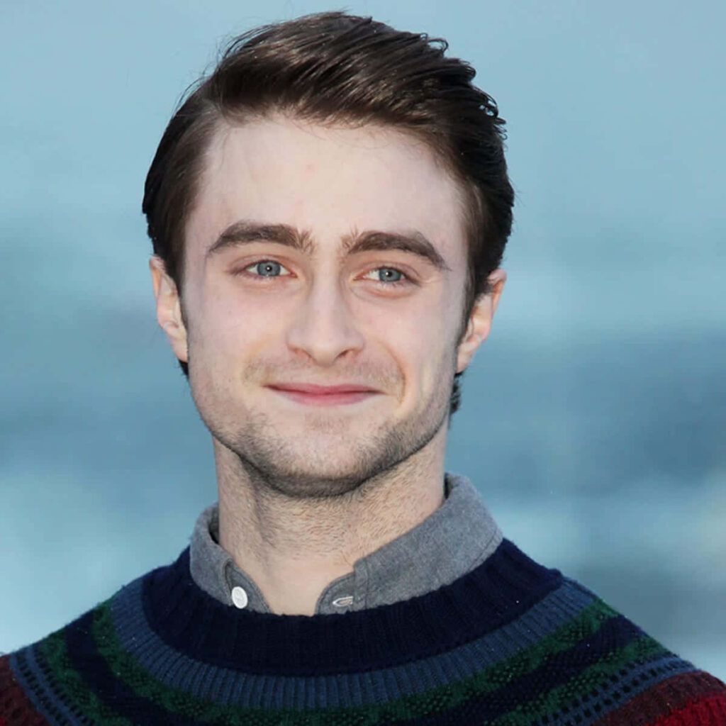 Daniel Radcliffe wallpaper soft blue background relaxed smile casual style dark striped sweater