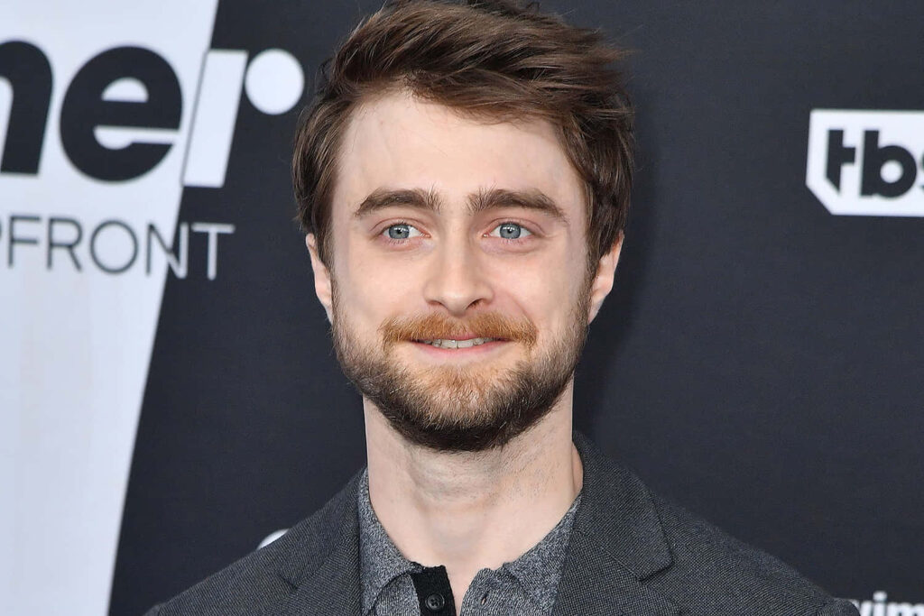 Daniel Radcliffe in gray blazer formal event monochrome background stylish celebrity wallpaper