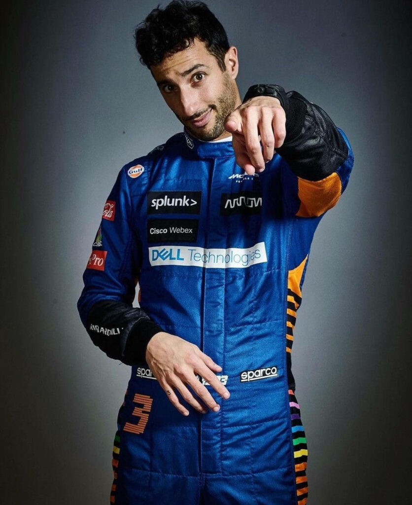 Daniel Ricciardo in blue racing suit pointing at camera with playful expression Formula 1 driver wallpaper