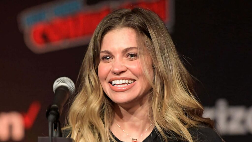 Danielle Fishel smiling warmly speaking at lively convention vibrant event wallpaper background