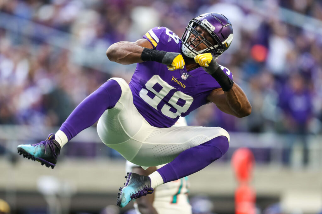 Danielle Hunter Minnesota Vikings in intense action against Cincinnati Bengals NFL game stadium background Wallpaper