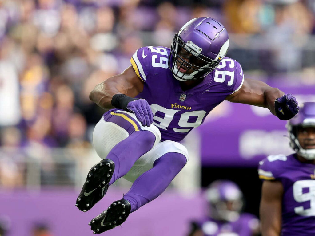 Danielle Hunter Minnesota Vikings mid-air jump action vibrant purple uniform stadium background Wallpaper