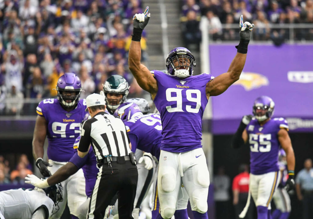 Danielle Hunter sacking quarterback in Minnesota Vikings purple uniform with stadium crowd background Wallpaper