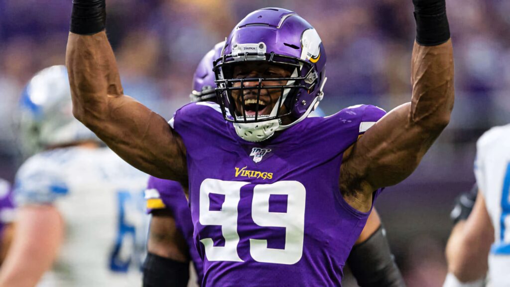 Danielle Hunter celebrating Vikings victory over Detroit Lions raising arms in purple uniform Wallpaper