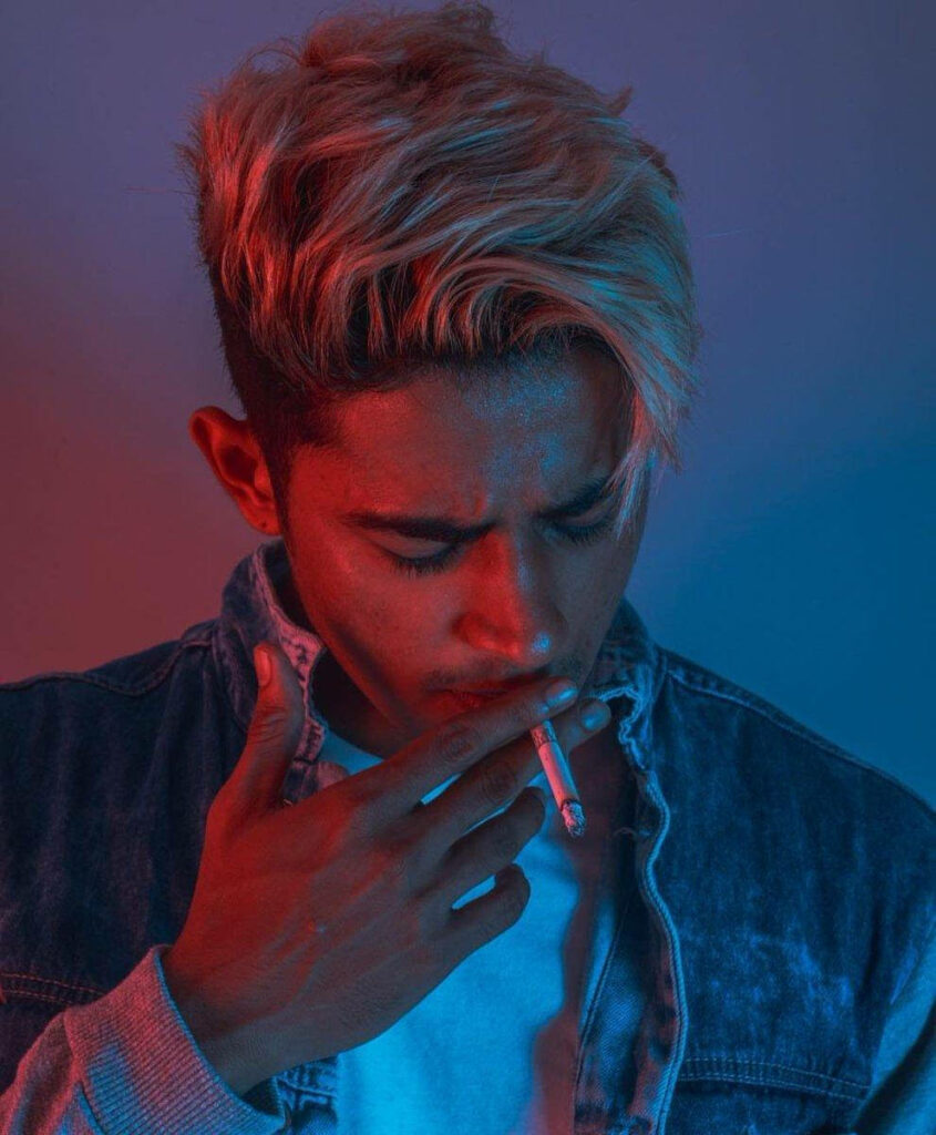Danish Zehen portrait with red blue lighting blonde hair denim jacket casual shirt cigarette cool mood Wallpaper