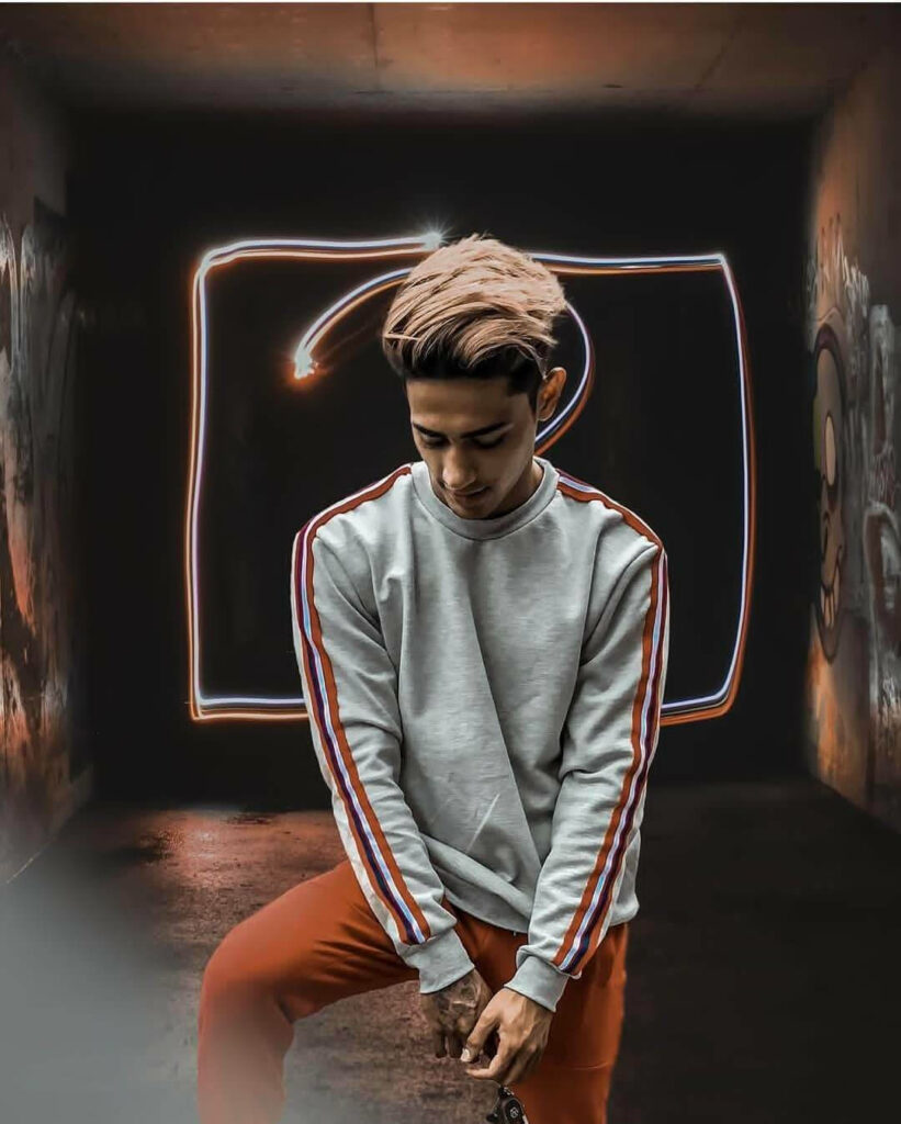 Danish Zehen in grey sweatshirt with stripes and orange pants in urban graffiti tunnel background Wallpaper