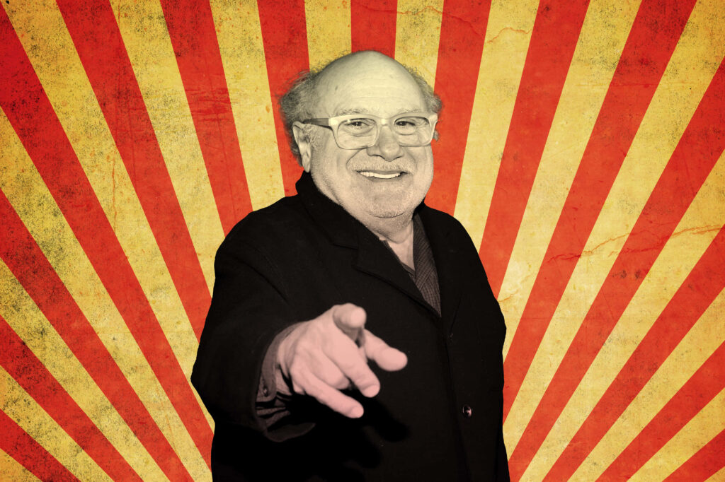 Danny DeVito smiling and pointing vibrant red and yellow retro wallpaper with vintage texture background