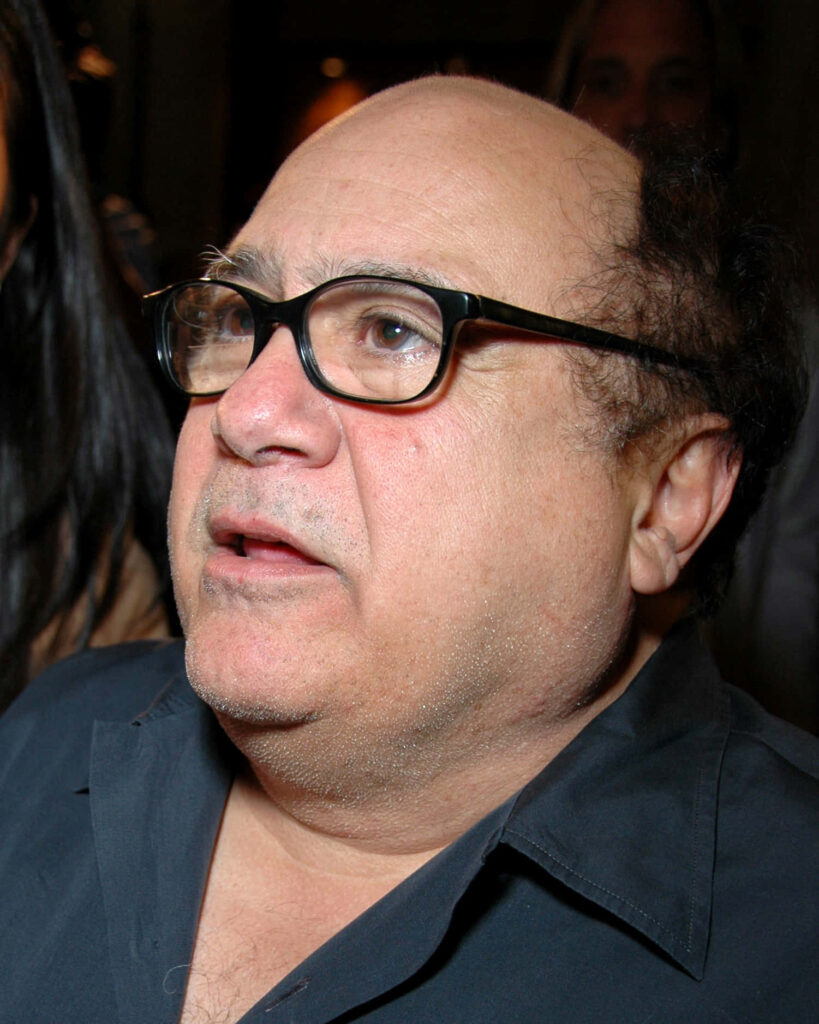 Danny Devito close-up portrait with signature glasses natural light soft focus wallpaper background