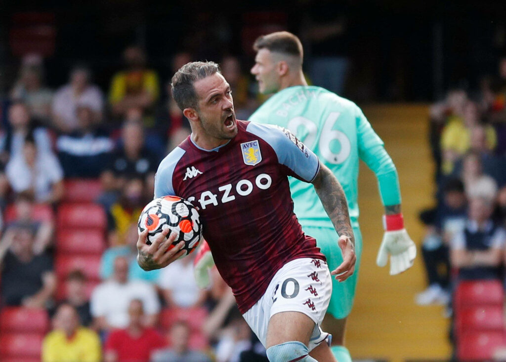Danny Ings shouting and holding match ball in Aston Villa kit during intense football match action Wallpaper