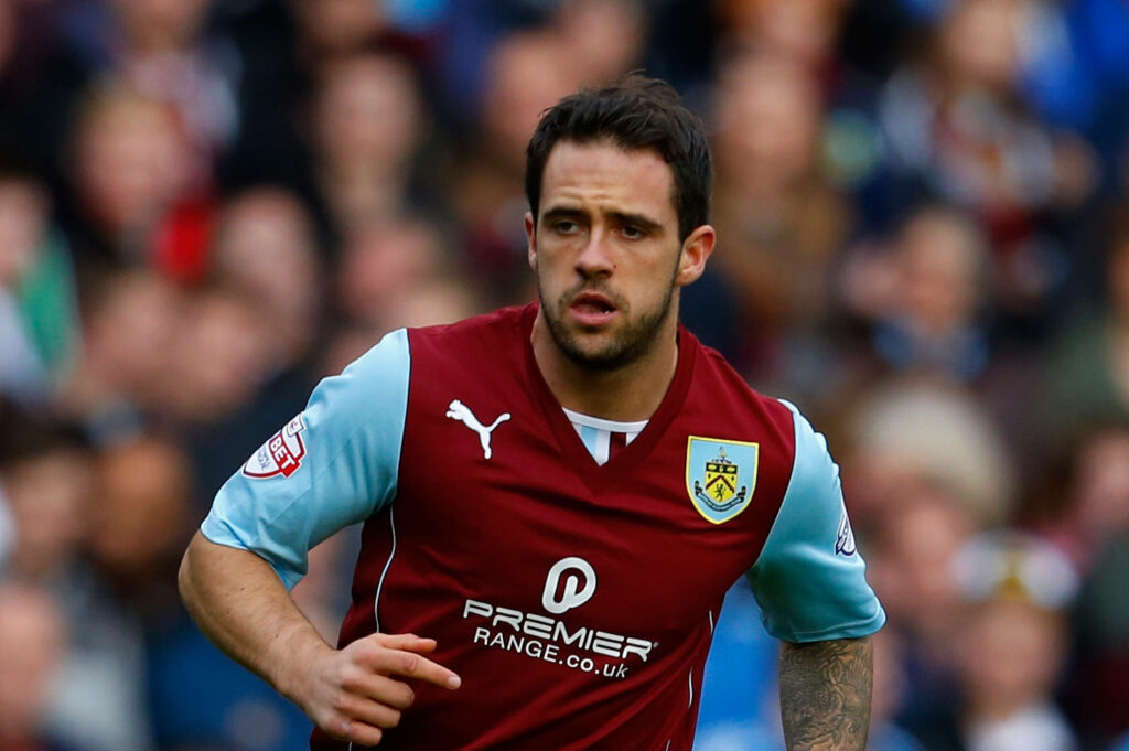 Danny Ings Burnley footballer in claret and blue kit captured in action on pitch with crowd Wallpaper