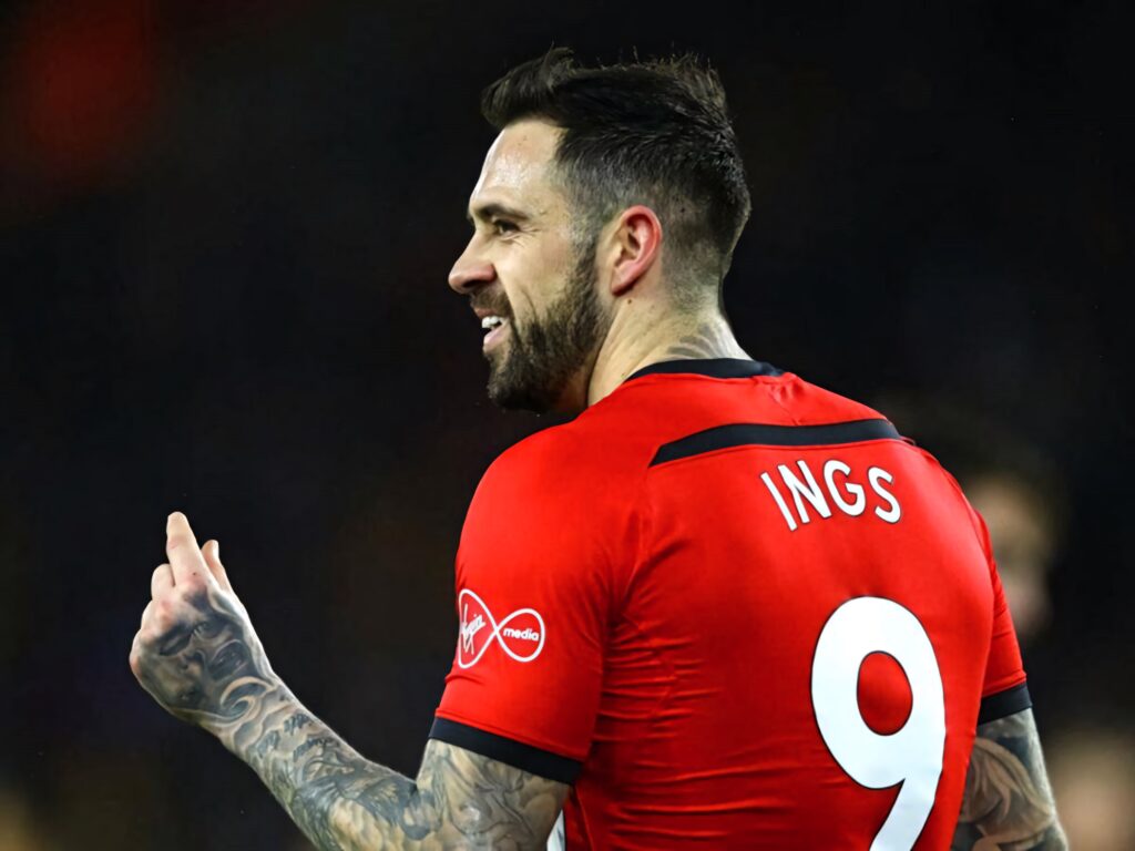 Danny Ings celebrating in red football jersey number 9 showing tattoos dark blurred sports background Wallpaper
