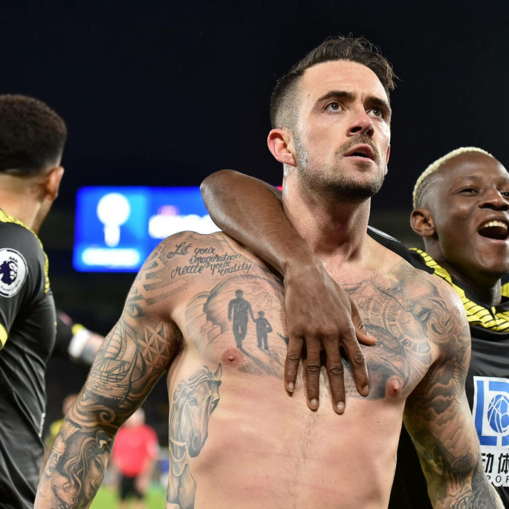 Danny Ings shirtless on football field showing tattoos under stadium lights during Premier League match Wallpaper