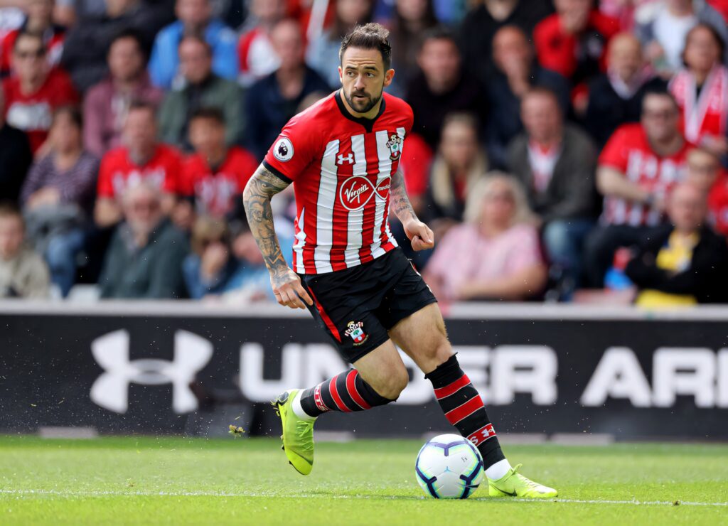 Danny Ings dribbling ball in red and white Southampton FC kit on vibrant green pitch with crowd Wallpaper