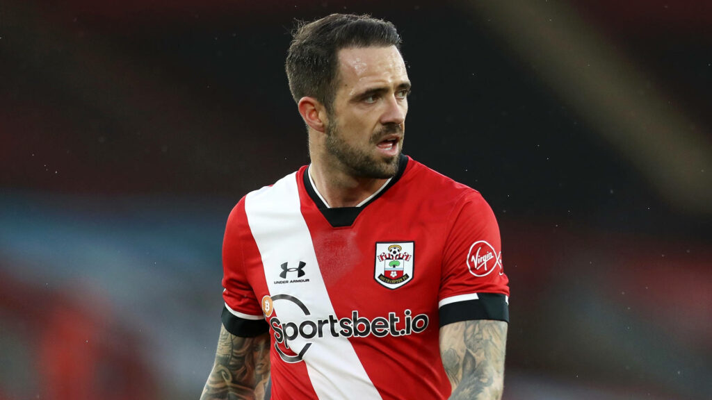 Danny Ings in Southampton FC red white jersey focused on pitch with tattooed arms stadium background Wallpaper