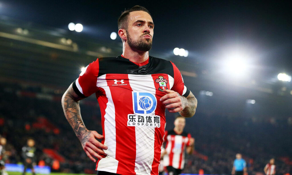 Danny Ings jogging on pitch in Southampton kit under bright stadium lights during intense match Wallpaper