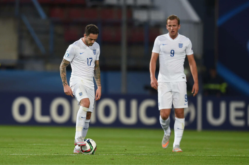 Danny Ings and Harry Kane in England white kits focused during intense football match wallpaper
