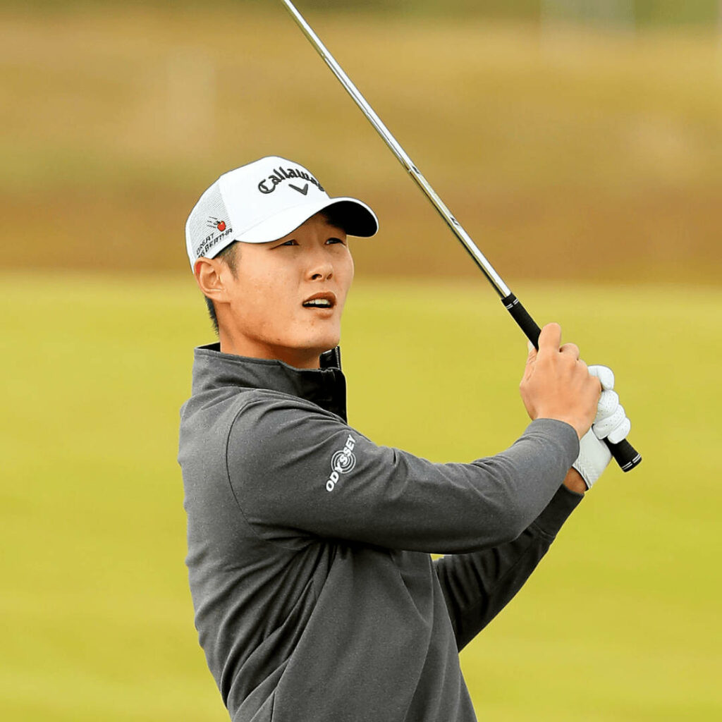 Professional golfer Danny Lee mid-swing in stylish attire wearing Callaway cap on golf course background Wallpaper
