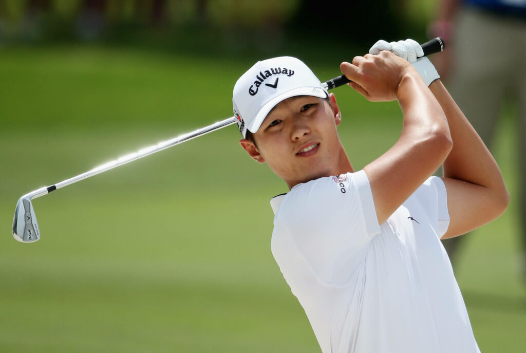 Golfer Danny Lee mid-swing on green course wearing white shirt and Callaway cap wallpaper
