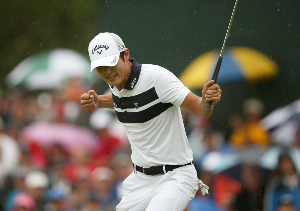 Professional golfer Danny Lee celebrating victory in white black outfit on vibrant golf course background Wallpaper