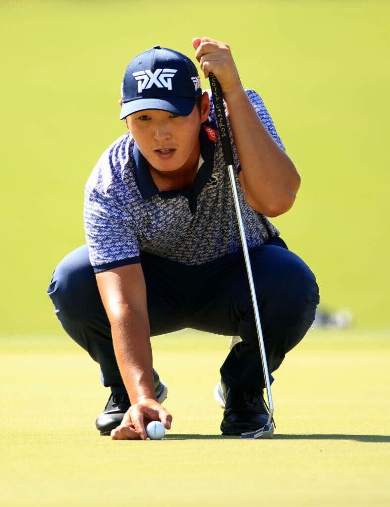 Danny Lee professional golfer lining up putt on bright green golf course focused in blue shirt Wallpaper