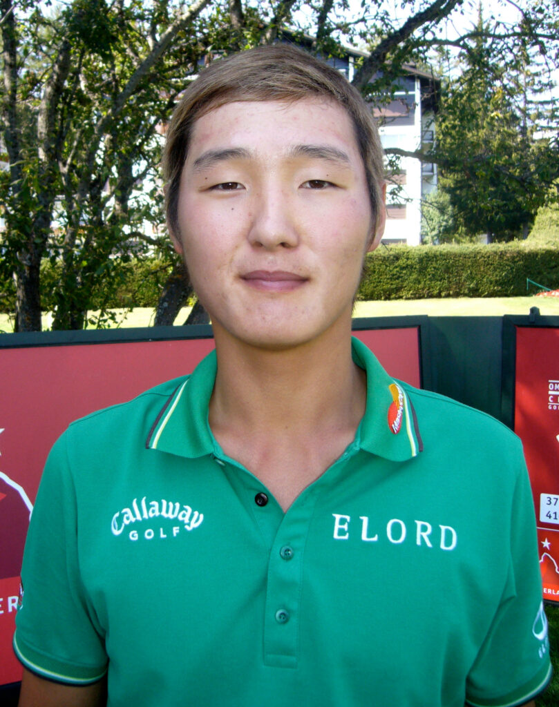 Danny Lee in green golf shirt outdoors on golf course with lush trees summer wallpaper background