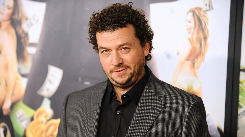 Danny McBride in gray checkered suit black shirt vibrant colorful playful artwork wallpaper