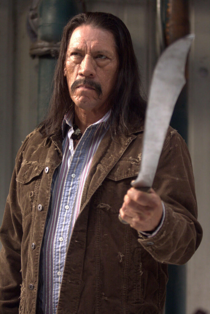 Danny Trejo intense pose with machete rugged jacket striped shirt dramatic lighting wallpaper