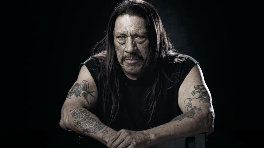 Danny Trejo intense gaze full sleeve tattoos dramatic lighting dark background portrait wallpaper
