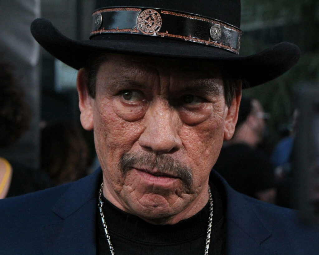 Danny Trejo intense expression rugged look black hat navy blazer chain necklace wallpaper background