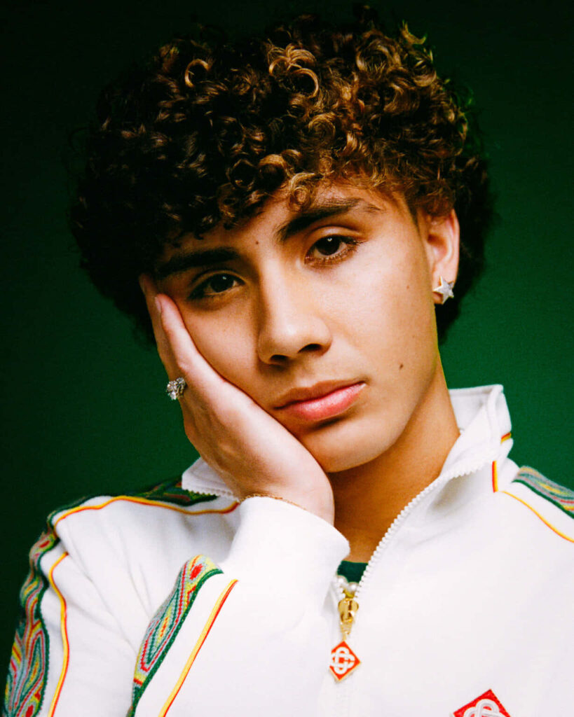 DannyLux close-up portrait with white jacket on dark green background soft lighting wallpaper