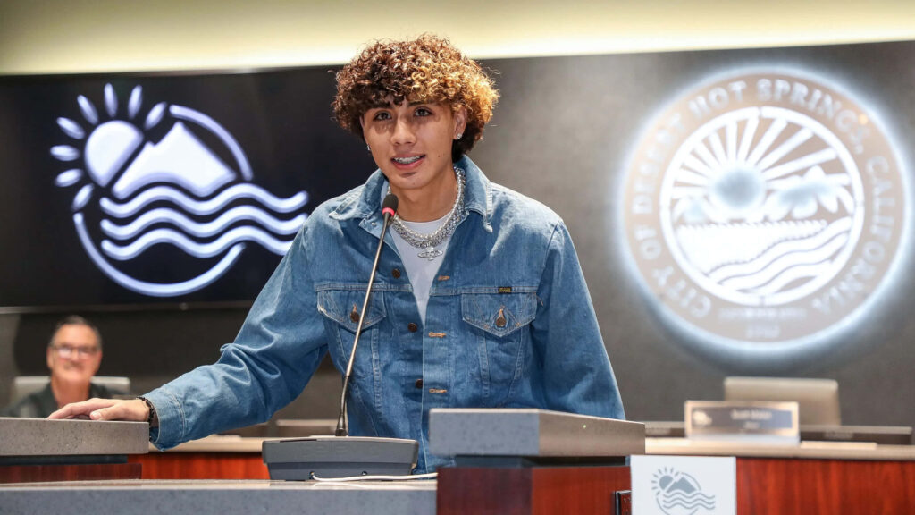 DannyLux wallpaper singer in light denim jacket with silver chains at podium city emblem background
