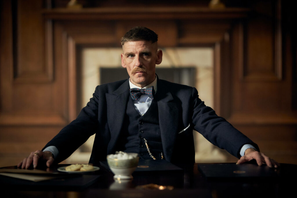 Dapper and Deadly: Arthur Shelby's Stylish Suited Stance - Striking Peaky Blinders 8k Backdrop Wallpaper