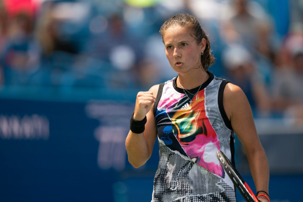 Daria Kasatkina celebrates tennis victory wearing vibrant patterned outfit on blue stadium court Wallpaper