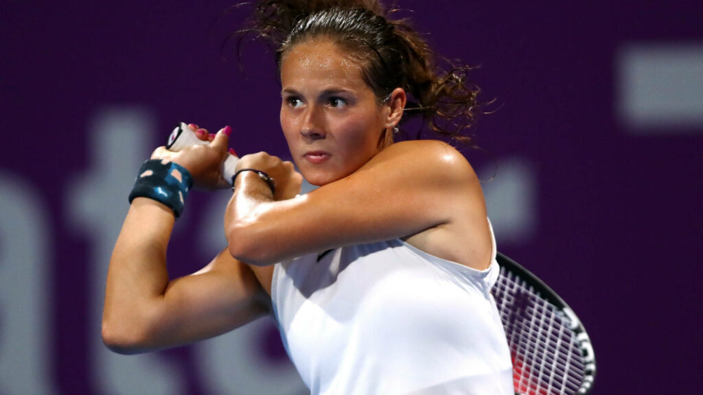 Daria Kasatkina mid-swing tennis action with intense focus vivid lighting deep purple background Wallpaper