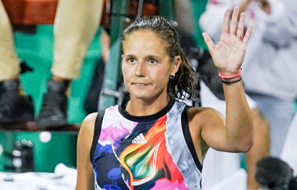 Daria Kasatkina waving wearing vibrant colorful shirt with abstract patterns at sports event Wallpaper