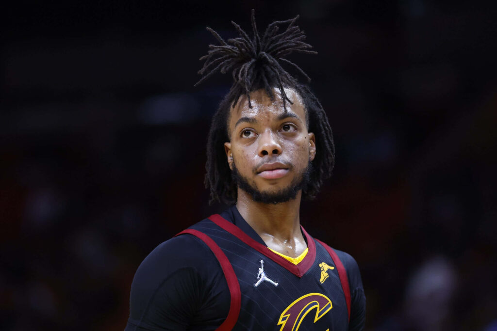 Darius Garland in Cleveland Cavaliers jersey focused on court under dramatic lighting intense game action Wallpaper