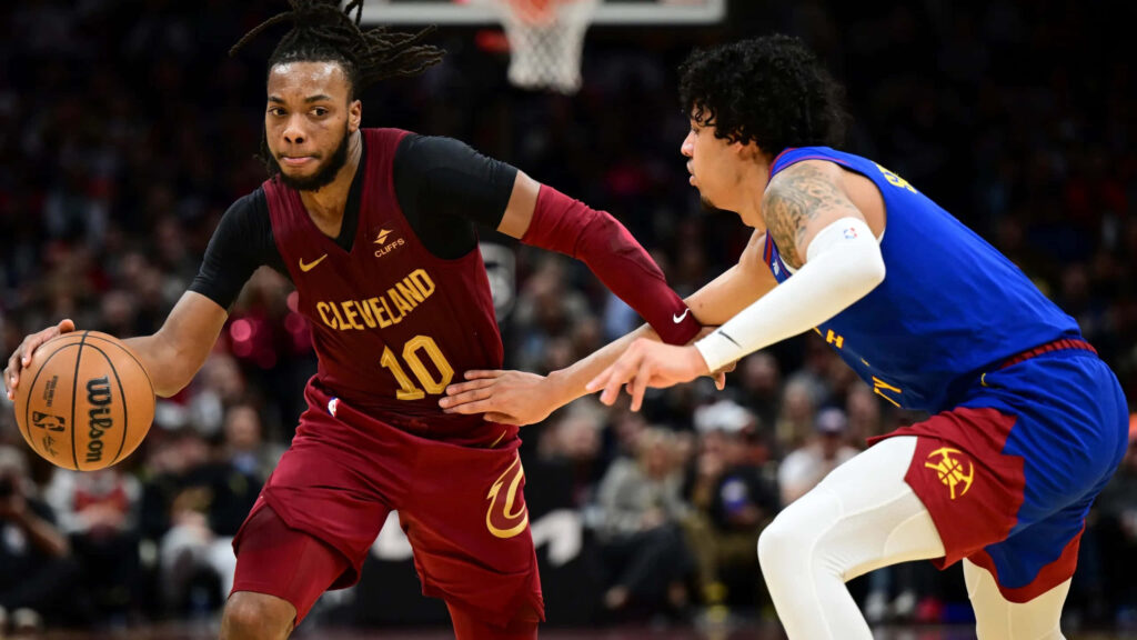 Cleveland Cavaliers guard Darius Garland dribbles past Denver Nuggets guard Julian Strawther in NBA game action Wallpaper