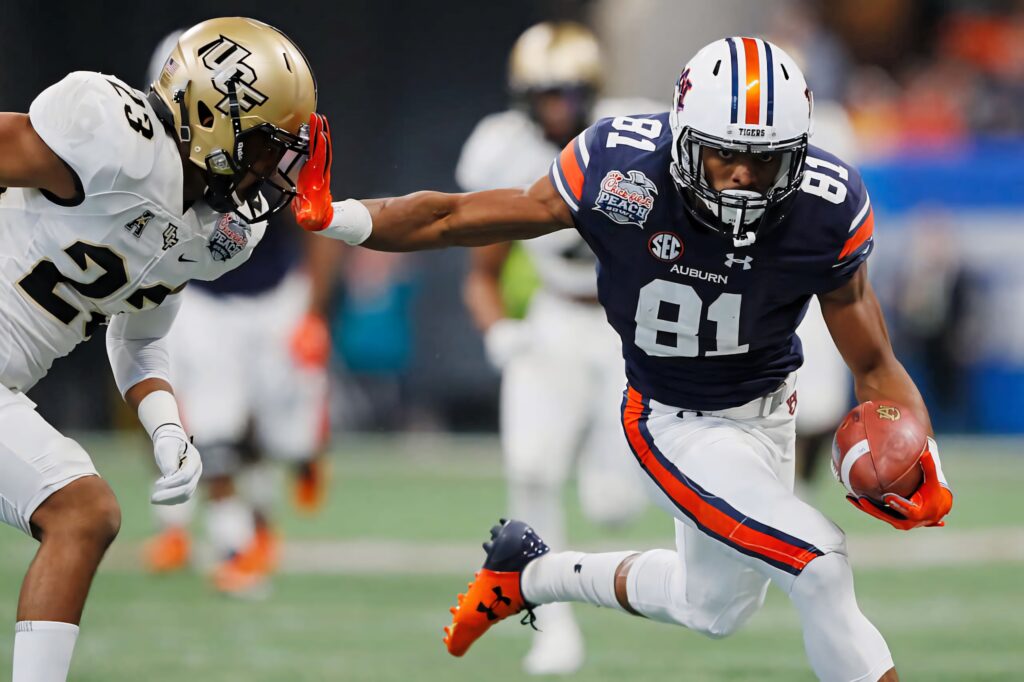 Darius Slayton Auburn wide receiver sprinting past UCF defender in vibrant college football action Wallpaper