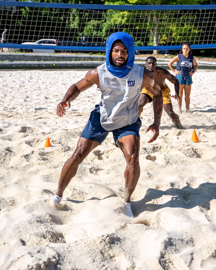 Darius Slayton football training on sunny beach with sand volleyball nets intense conditioning session Wallpaper