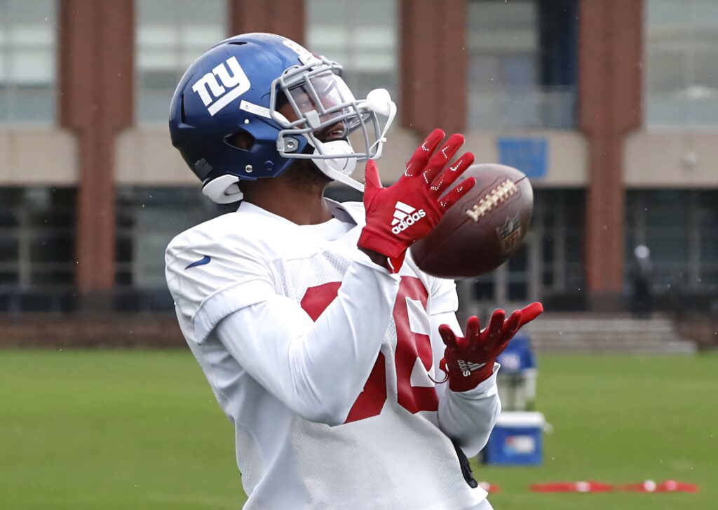 Darius Slayton catching football in New York Giants uniform with red gloves on training field Wallpaper