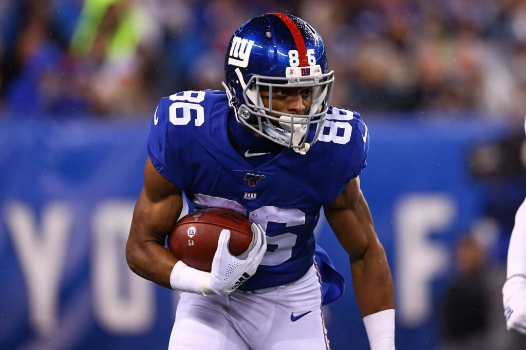 Darius Slayton New York Giants running with football in blue white uniform on stadium field Wallpaper
