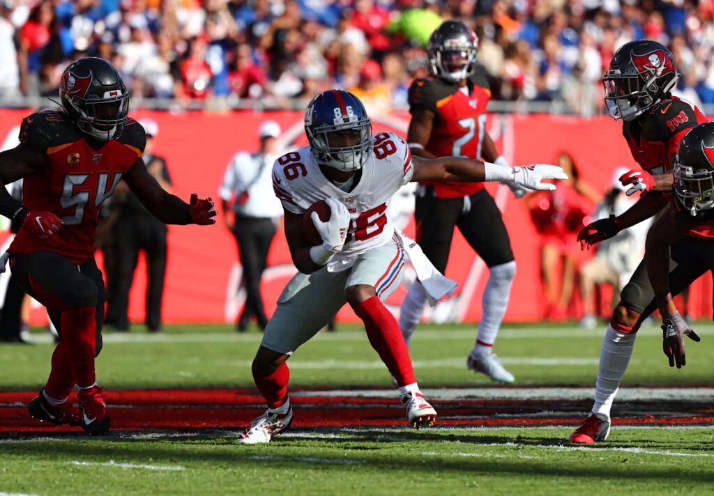 Darius Slayton runs with the football in New York Giants uniform against defenders NFL action Wallpaper