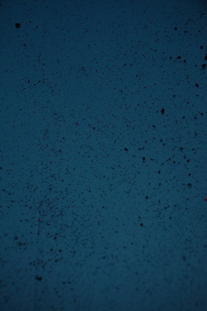 Dark blue concrete wall wallpaper with rough porous texture and deep navy minimalist design