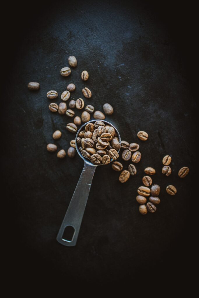 Dark Coffee Beans Wallpaper with Metal Spoon - Atmospheric Background